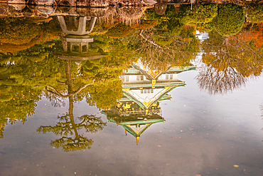 Reflection of the castle in a calm zen garden. Golden warm evening lights. Osaka, Japan