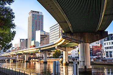 Nakanoshima in Osaka, Japan. A green Island park in the center of Osaka. Highway bridges over Dojima River in Osaka.