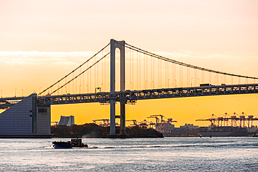 View from River Sumida at sunrise, Tokyo Rainbow bridge and cranes of Odaiba, Tokyo, Honshu, Japan, Asia