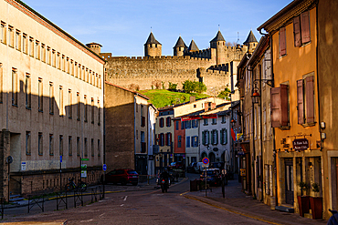Old town in Rue Trivalle looking along the street with the castle in the background. Evening atmosphere in Carcassonne, Languedoc-Roussillon, France