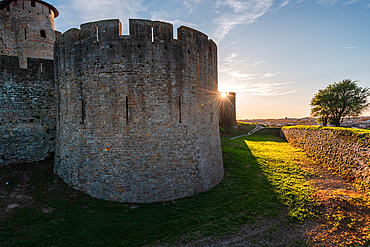 Close up of the corner wall tower with sun rays behind it. Evening atmosphere in Carcassonne, Languedoc-Roussillon, France