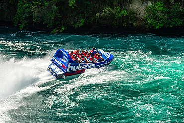 Huka falls near lake Taupo. Turquoise water white water jet boat rafting at the waterfall in Waikato River. New Zealand. Close up of the boat