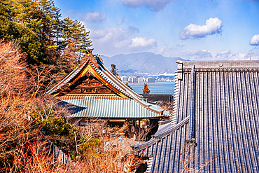 Traditional Rooftops of Daishoin Temple Framed by Trees with View of Seto Inland Sea on Miyajima Island, Japan