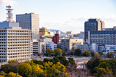 Urban Skyline of Hiroshima City with Office Buildings and Tree-Lined Rivers at Sunset, Viewed from Hiroshima Castle main tower Japan