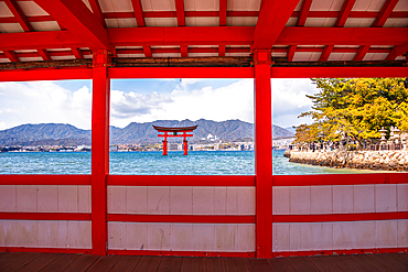 Framed View of the Itsukushima Shrine Torii Gate Through the Red Architecture of the Shrine on Miyajima Island, Japan