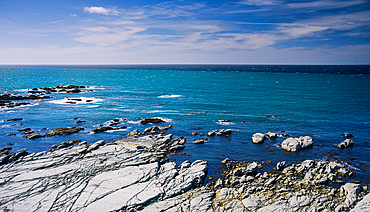 Rocky Shoreline and Vibrant Blue Ocean Waters Stretching Into the Horizon at Kaikoura Peninsula, New Zealand