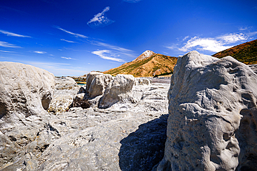 Limestone Rock Formations on Ward Beach Framed by Coastal Hills and Blue Sky, Marlborough, New Zealand