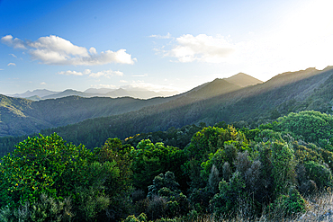 Dramatic Light Rays Breaking Through Evening Cloud Over Lush Hills Along French Pass Road, Marlborough Sounds, New Zealand
