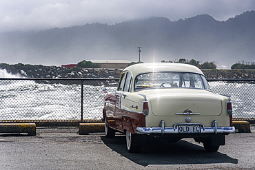 Classic Cream and Red Vintage Car Parked by the Waterfront on a Rainy Day in Hokitika, New Zealand