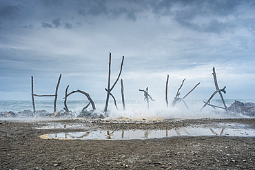 Creative Driftwood “Hokitika” Beach Sculpture Against Stormy Sky on the West Coast, New Zealand