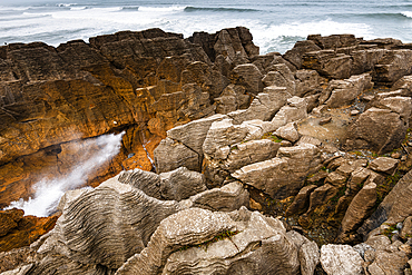 Dramatic Sea Burst from Blowhole in Layered Limestone Formations at Pancake Rocks, West Coast, New Zealand