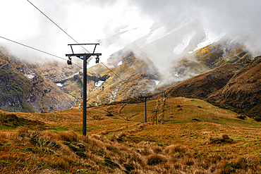 Grassy fields in front of the towering slopes of Mount Taranaki, electric grid, North Island, New Zealand, Pacific