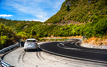 Forked Rural Road Through Grassy Hills Under Bright Blue Sky, South Island Backcountry, New Zealand