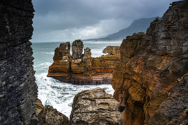 Dramatic View Through Rock Formations Toward Sea Stacks at Pancake Rocks, Punakaiki, New Zealand
