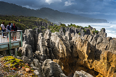Visitors on Walkway Above Dramatic Limestone Formations at Pancake Rocks, Punakaiki, New Zealand