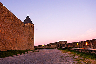 Fortified towers and long defensive walls at dusk along Rue de la Barbacane, Cité de Carcassonne, Occitanie, France