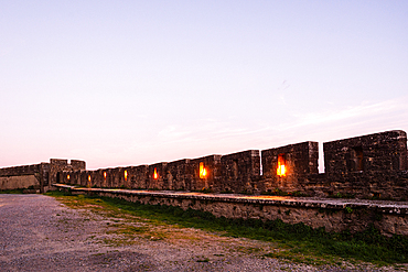 Dusk over the illuminated crenellated walls of Rue de la Barbacane in the fortified Cité de Carcassonne, France