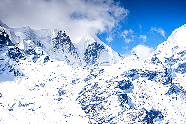Glaciated Slopes and Jagged Himalayan Summits Viewed from the Kyanjin Ri Summit under a Bright Blue Sky with Scattered Clouds