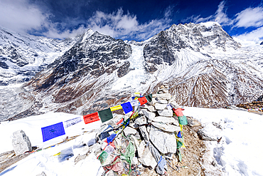 Stone Cairn Adorned with Prayer Flags on the Wind-Swept Summit of Kyanjin Ri with Langtang Lirung and Langtang Glacier Behind