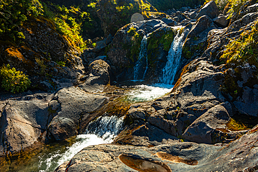 Wilkies Pools, warm sunlight on waterfalls in Mount Taranki National Park, North Island, New Zealand, Pacific