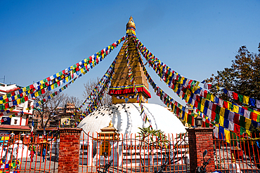 Small white stupa adorned with prayer flags at Charumati Stupa a peaceful Buddhist site nestled in Kathmandu’s city center