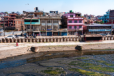 Colorful buildings overlooking the polluted Bagmati River with stone ghats along the banks near the Pashupatinath complex in Kathmandu, Nepal