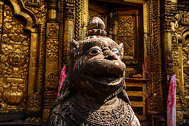 Stone lion guardian statue with intricate carvings at the entrance of Changu Narayan Temple, a UNESCO World Heritage Site in Nepal