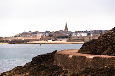 The walled city of Saint-Malo viewed from the rocky coastline of Dinardwith the spire of Saint-Vincent Cathedral rising above the skyline