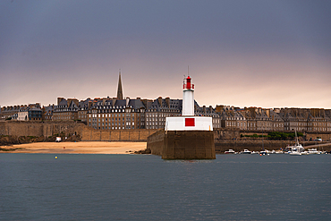 Red and White Lighthouse on Breakwater with Historic Walled City of Saint-Malo in the Background in Brittany France