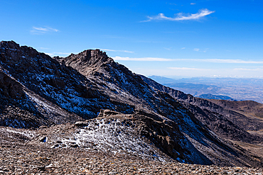 Ruins of an old high-altitude building with snow in the Sierra Nevada National Park, Andalusia, Spain. A stark reminder of the region’s harsh climate and history.