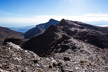 Dramatic rocky ridges on the approach to Pico de Caballo, Sierra Nevada National Park, Andalusia, Spain. The highest peak of mainland Spain towers above the rugged alpine terrain.