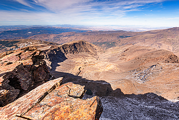 View from the Summit of pico de la veleta Jagged rocks and barren ridges under blue skies in the Sierra Nevada, Andalusia, Spain.