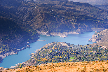 Sweeping view over turquoise reservoir of Guejar Sierra and mountain valleys in the Sierra Nevada, Andalusia, Spain.
