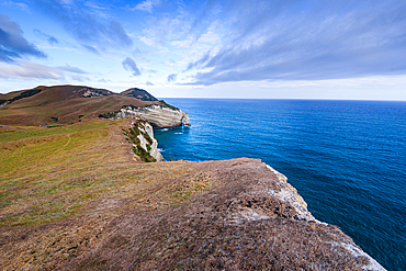 Panoramic view of the steep headlands and turquoise Tasman Sea at Cape Farewell, the northern tip of the South Island, New Zealand. Puponga Farm Park