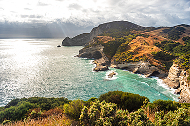 Rugged cliffs and turquoise waters along the dramatic Cape Farewell coastline in Golden Bay, South Island, New Zealand.