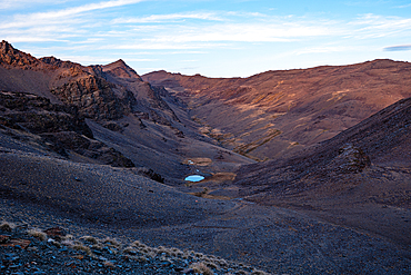 Wast Valley with remote alpine glacial lake nestled below Cerro del Caballo in the Sierra Nevada National Park, Andalusia, Spain.
