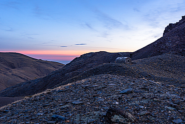 Warm sunset light falling across the rocky ridges surrounding Cerro del Caballo in Sierra Nevada National Park, Andalusia, Spain.