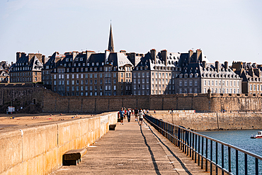 Panoramic view of Saint-Malo’s historic walled city and seafront ramparts, Brittany, France, with waves against the stone walls