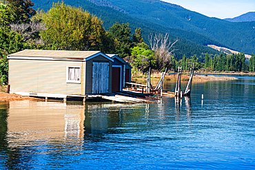 Classic wooden boathouse sits on the shoreline of Marlborough Sounds, a famous boating region in South Island, New Zealand.