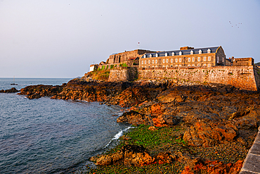 Historic Castle Cornet fortress stands on coastal rocks guarding St Peter Port at low tide, Guernsey, Channel Islands.
