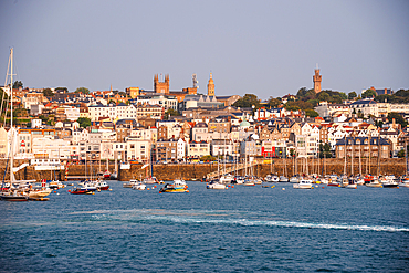 Waterfront view of St Peter Port, Guernsey, Channel Islands, with boats moored in the harbor in tranquil morning light