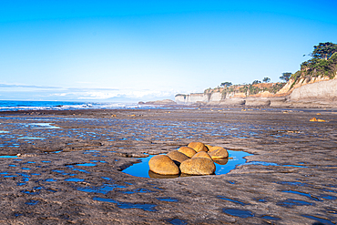Cluster of granite boulders on Cape Foulwind beach at low tide Tasman Sea horizon West Coast New Zealand