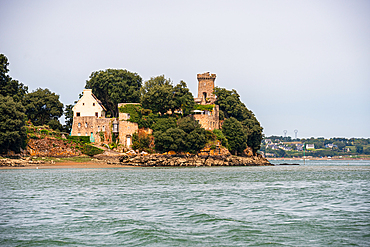 Neo-Gothic Château de Péhou rising on a wooded peninsula of the Rance estuary near Plouër-sur-Rance, Brittany, France.