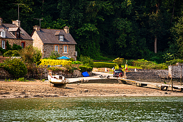 Traditional granite cottages and slipway at a small hamlet on the Rance estuary, Brittany, France.