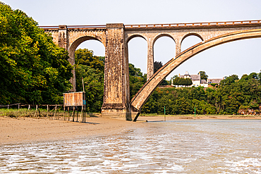 The historic Viaduc de Lessard railway bridge with elegant arches spanning the River Rance near Dinan, Brittany, France.