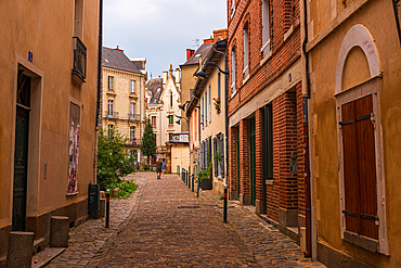 Narrow cobblestone alleyway with historic French houses in medieval old town Rennes Brittany France