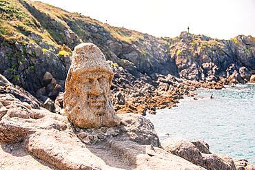 sculpted stone face on coastal rocks overlooking sea near Saint-Malo Brittany France
