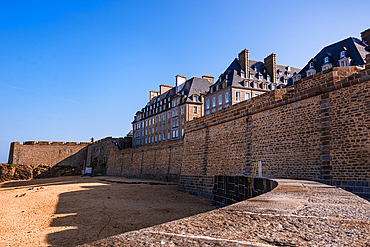 Saint-Malo ramparts with historic stone buildings above. Sandy beach below