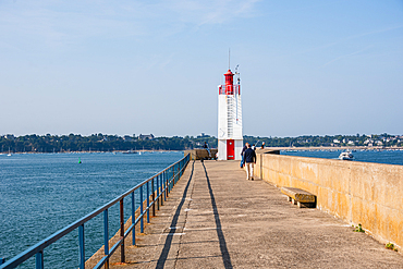 Long stone pier with red and white lighthouse at Saint-Malo harbor Brittany France