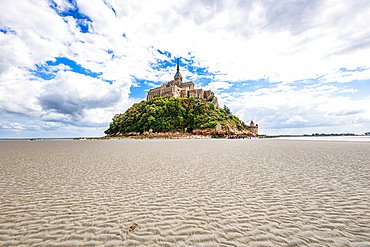 Wide-angle image of Mont Saint-Michel during low tide, showing the dramatic isolation of the island fortress.